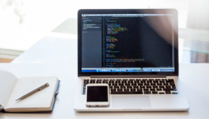 コードの映ったパソコンとスマートフォン